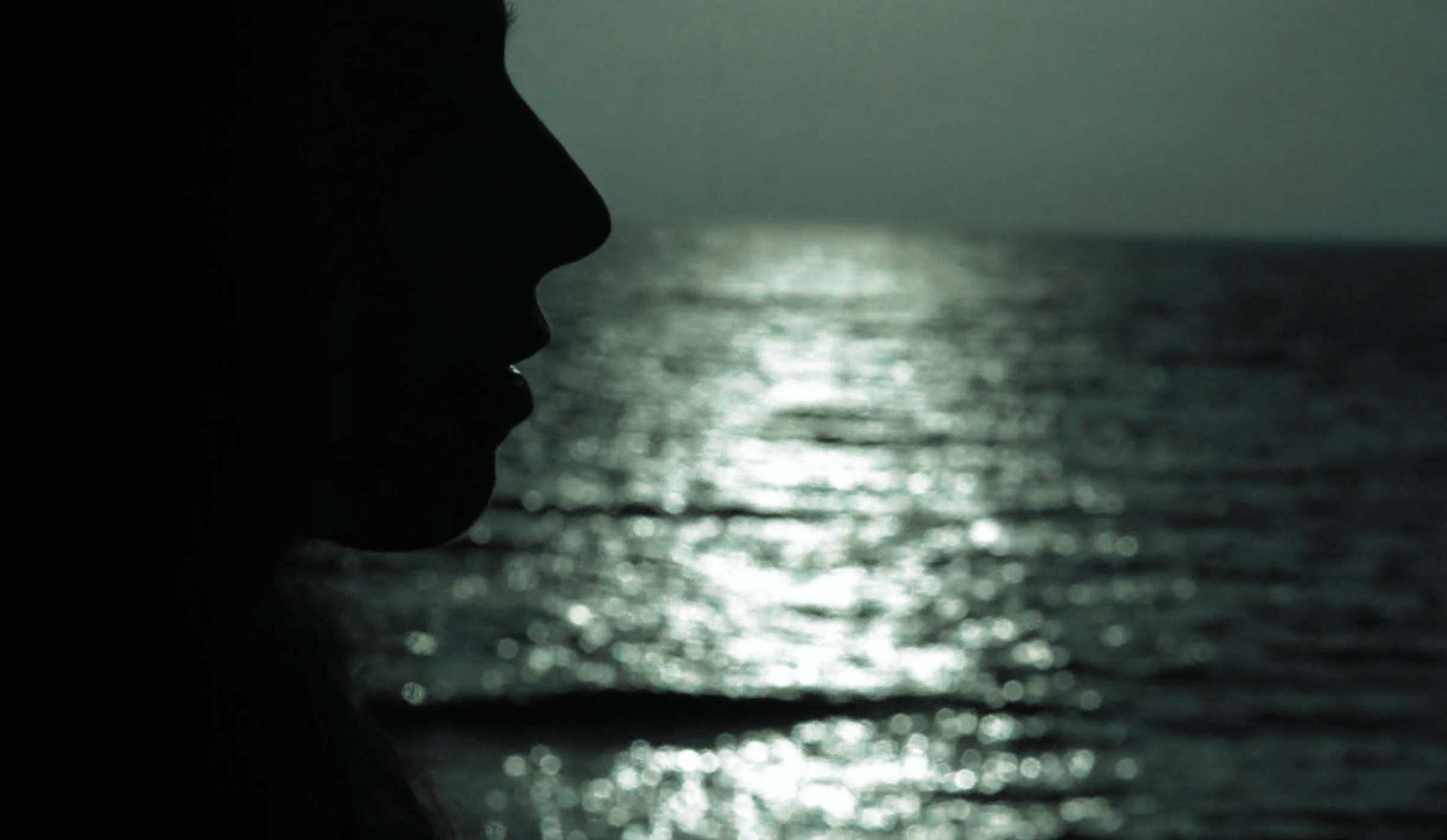 Sara in silhouette against light on the sea