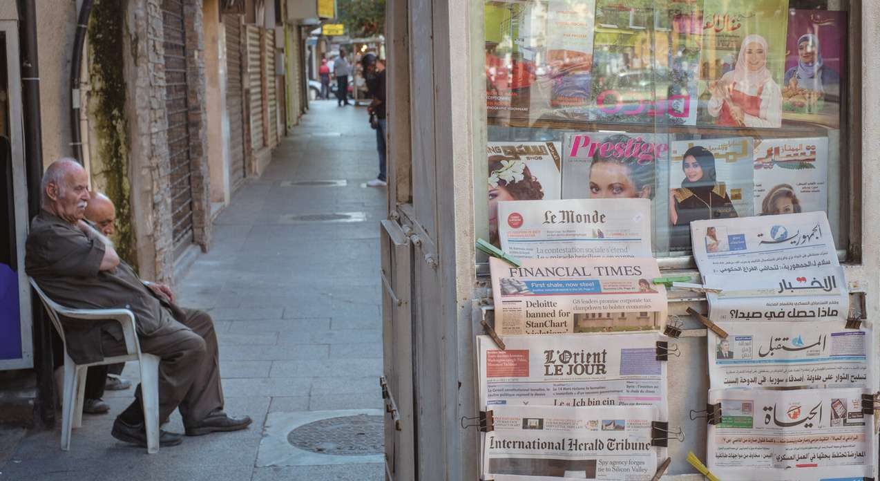 Men sitting beside a Beirut newsstand